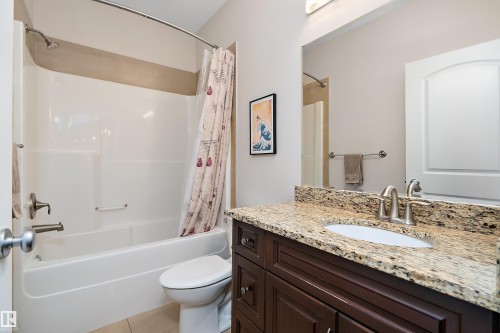 Bathroom with vanity, shower / bath combo, and light tile patterned flooring - 10623 75 Avenue, Edmonton, AB - Indoor Photo Showing Bathroom