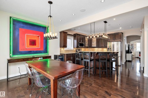 Dining space with arched walkways, suspended lighting, and dark wood-style flooring - 10623 75 Avenue, Edmonton, AB - Indoor Photo Showing Dining Room