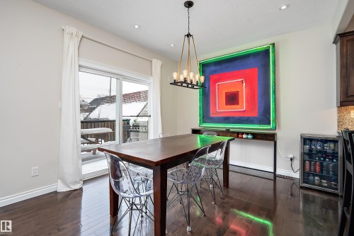 Dining space with beverage cooler, dark wood-style flooring, and hanging lights - 10623 75 Avenue, Edmonton, AB - Indoor Photo Showing Dining Room