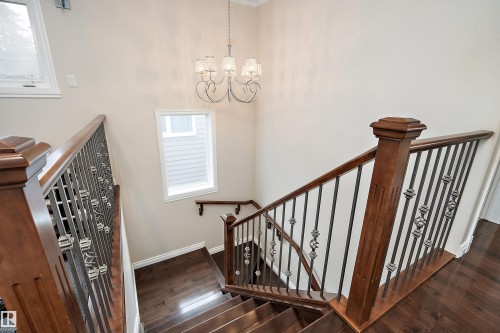 Stairway featuring wood-type flooring, a chandelier, and a high ceiling - 10623 75 Avenue, Edmonton, AB - Indoor Photo Showing Other Room