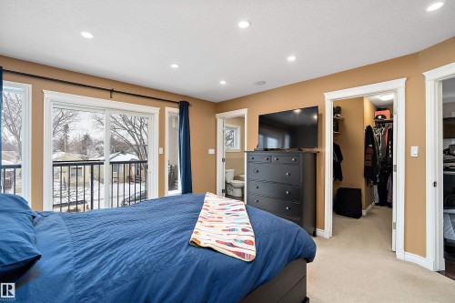 Bedroom featuring a spacious closet, light colored carpet, access to outside, recessed lighting, and ensuite bath - 10623 75 Avenue, Edmonton, AB - Indoor Photo Showing Bedroom