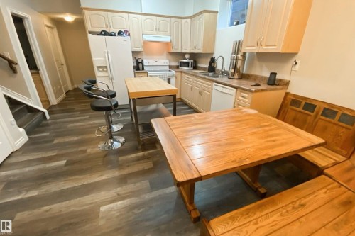 Kitchen with white appliances, dark wood-type flooring, and light countertops - 10623 75 Avenue, Edmonton, AB - Indoor