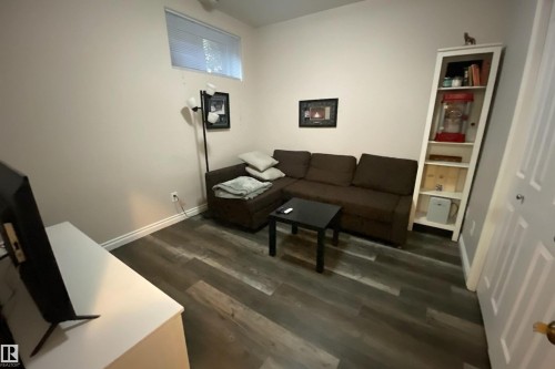 Living area featuring dark wood-style floors and baseboards - 10623 75 Avenue, Edmonton, AB - Indoor