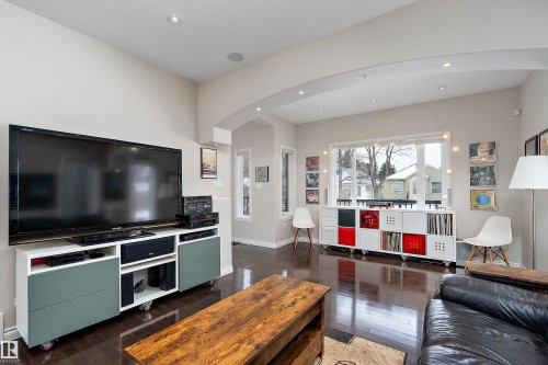 Living area featuring arched walkways, dark wood-style flooring, and recessed lighting - 10623 75 Avenue, Edmonton, AB - Indoor Photo Showing Living Room