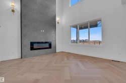 Unfurnished living room featuring parquet floors, a high ceiling, and a fireplace - 