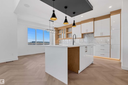 Kitchen featuring open shelves, backsplash, parquet floors, and an island with sink - 108 Eldridge Point(E), St. Albert, AB - Indoor Photo Showing Kitchen