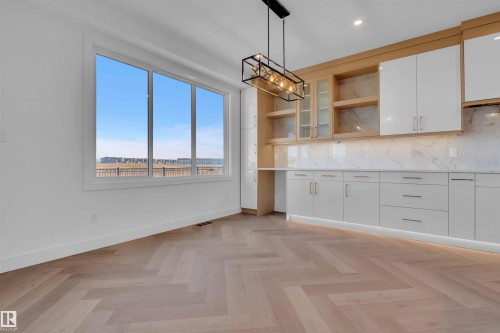 Kitchen with open shelves, white cabinets, tasteful backsplash, decorative light fixtures, and light stone countertops - 108 Eldridge Point(E), St. Albert, AB - Indoor