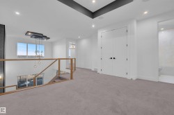 Carpeted spare room featuring suspended lighting and baseboards - 