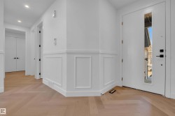 Entrance foyer featuring a decorative wall, parquet floors, a wainscoted wall, and recessed lighting - 