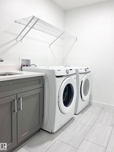 Laundry area featuring washer and clothes dryer and cabinet space - 19704 29 Avenue, Edmonton, AB - Indoor Photo Showing Laundry Room