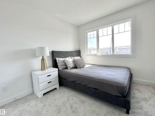 Bedroom with light colored carpet and a textured ceiling - 19704 29 Avenue, Edmonton, AB - Indoor Photo Showing Bedroom
