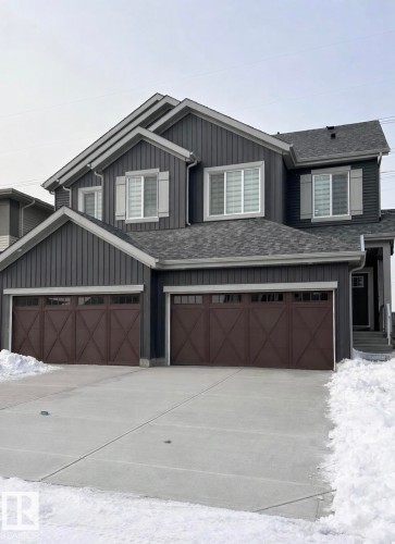 View of front facade with driveway, board and batten siding, and an attached garage - 19704 29 Avenue, Edmonton, AB - Outdoor