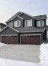 View of front facade with driveway, board and batten siding, and an attached garage - 19704 29 Avenue, Edmonton, AB  - Outdoor 