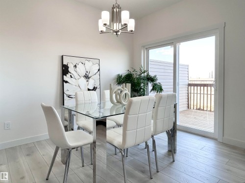 Dining room featuring light wood-type flooring and a chandelier - 19704 29 Avenue, Edmonton, AB - Indoor Photo Showing Dining Room
