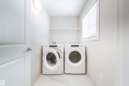 Laundry area with washer and clothes dryer and baseboards - 2237 56 Street, Edmonton, AB - Indoor Photo Showing Laundry Room