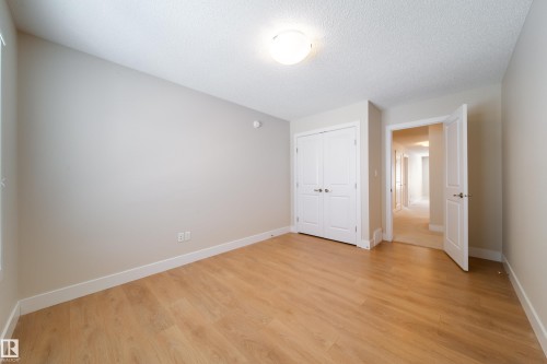 Unfurnished bedroom with light wood finished floors, a textured ceiling, and a closet - 2237 56 Street, Edmonton, AB - Indoor Photo Showing Other Room