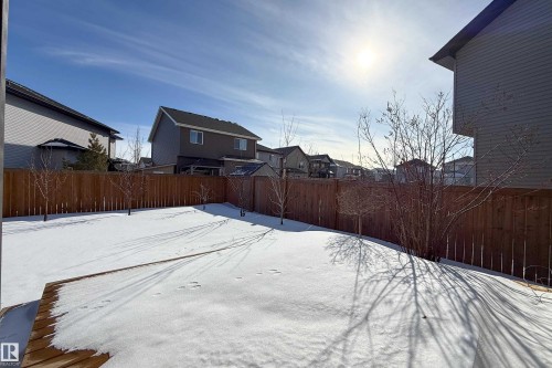 Snowy yard featuring a residential view and a fenced backyard - 2237 56 Street, Edmonton, AB - Outdoor With Exterior