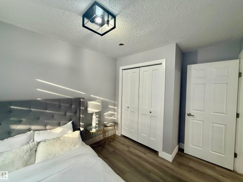 Bedroom featuring dark wood-style flooring, a closet, and a textured ceiling - 2915 145 Avenue, Edmonton, AB - Indoor Photo Showing Bedroom
