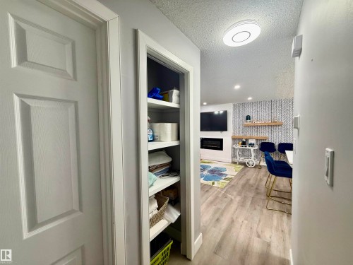 Corridor featuring a textured ceiling, light wood-style flooring, wallpapered walls, an accent wall, and recessed lighting - 2915 145 Avenue, Edmonton, AB - Indoor Photo Showing Other Room