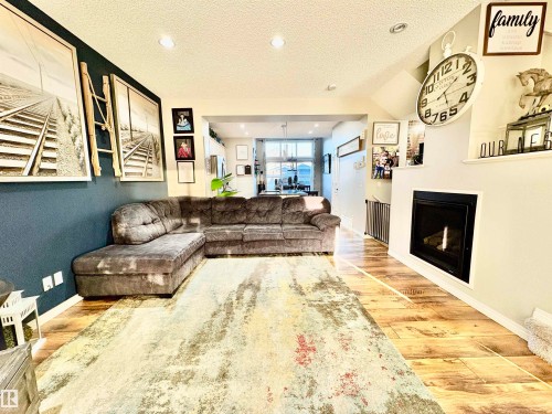 Living room featuring a textured ceiling, a fireplace, light wood finished floors, and recessed lighting - 425 Sheppard Boulevard, Leduc, AB - Indoor With Fireplace