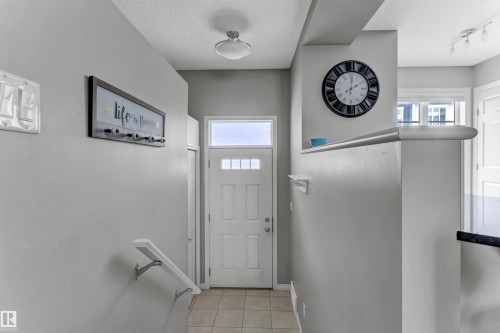 Doorway to outside with healthy amount of natural light, a textured ceiling, and tile patterned floors - #127 2905 141 Street, Edmonton, AB - Indoor Photo Showing Other Room