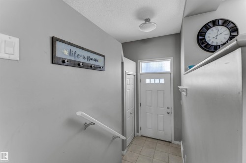 Doorway to outside with tile patterned floors and a textured ceiling - #127 2905 141 Street, Edmonton, AB - Indoor Photo Showing Other Room