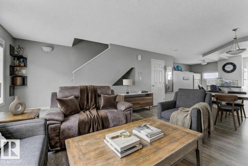 Living area with wood finished floors and a textured ceiling - #127 2905 141 Street, Edmonton, AB - Indoor