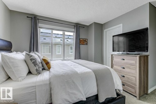 Bedroom with a textured ceiling and light colored carpet - #127 2905 141 Street, Edmonton, AB - Indoor Photo Showing Bedroom