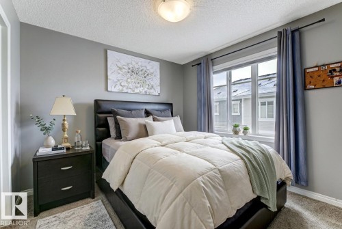 Bedroom featuring light colored carpet and a textured ceiling - #127 2905 141 Street, Edmonton, AB - Indoor Photo Showing Bedroom
