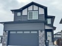 View of front of home featuring stone siding and a garage - 1703 152 Avenue, Edmonton, AB  - Outdoor 