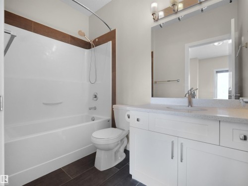 Full bathroom featuring vanity, tub / shower combination, and wood tiled floors - 8921 217 St Nw, Edmonton, AB - Indoor Photo Showing Bathroom