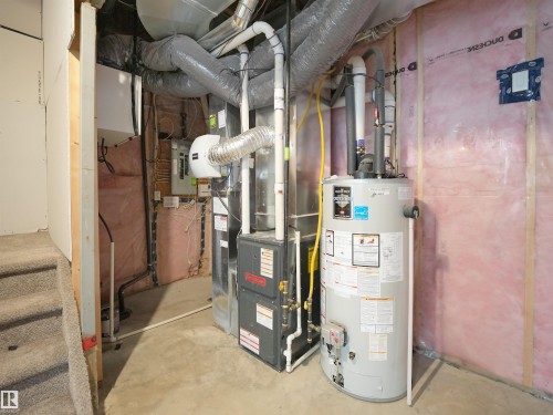 Utility room featuring gas water heater, heating unit, and electric panel - 8921 217 St Nw, Edmonton, AB - Indoor Photo Showing Basement