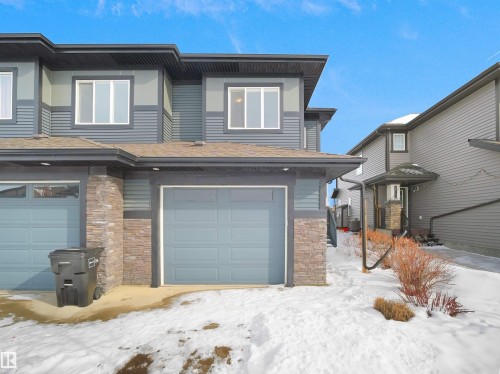 View of front of home featuring stone siding and a garage - 8921 217 St Nw, Edmonton, AB - Outdoor With Exterior