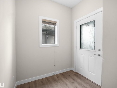 Doorway to outside with wood finished floors and baseboards - 8921 217 St Nw, Edmonton, AB - Indoor Photo Showing Other Room