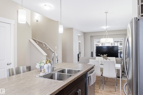 Kitchen with stainless steel appliances, hanging light fixtures, light countertops, and light wood-type flooring - 149 Hawks Ridge Boulevard, Edmonton, AB - Indoor Photo Showing Kitchen With Double Sink