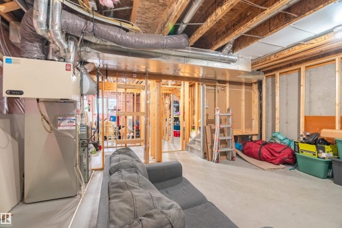 Unfinished basement featuring stairs and heating unit - 149 Hawks Ridge Boulevard, Edmonton, AB - Indoor Photo Showing Basement