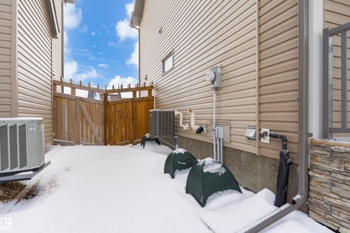 View of home's exterior featuring a central AC unit and a gate - 149 Hawks Ridge Boulevard, Edmonton, AB - Outdoor With Exterior