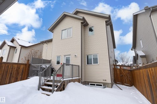Snow covered rear of property featuring a fenced backyard, a gate, and a deck - 149 Hawks Ridge Boulevard, Edmonton, AB - Outdoor With Exterior