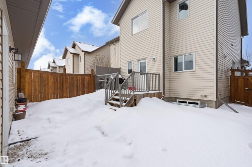 Snow covered back of property featuring a wooden deck and a fenced backyard - 149 Hawks Ridge Boulevard, Edmonton, AB - Outdoor With Exterior