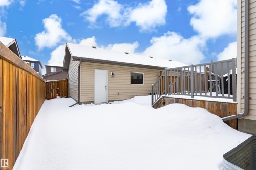 Snow covered rear of property featuring a fenced backyard and a deck - 149 Hawks Ridge Boulevard, Edmonton, AB - Outdoor With Exterior