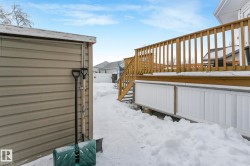 Yard covered in snow featuring stairs and a deck - 