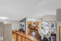 Dining space with a fireplace, a chandelier, granite tiled floors, and high vaulted ceiling - 