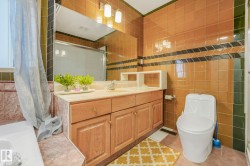Full bathroom with vanity, tile walls, a stall shower, light tile patterned floors, and a bath - 