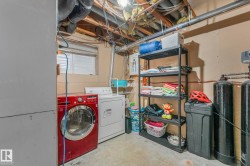Washroom with concrete floors, washing machine and clothes dryer, and electric panel - 