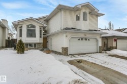 View of front of home with brick siding, an attached garage, and driveway - 