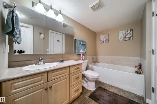 Bathroom featuring vanity, a bath, and a textured ceiling - 237 278 Suder Greens Drive, Edmonton, AB - Indoor Photo Showing Bathroom