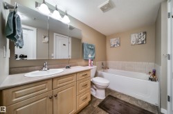 Bathroom featuring vanity, a bath, and a textured ceiling - 