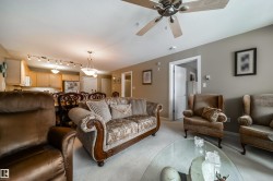 Living room featuring light colored carpet and a ceiling fan - 