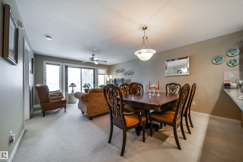 Dining area with light colored carpet, a textured ceiling, and ceiling fan - 237 278 Suder Greens Drive, Edmonton, AB - Indoor Photo Showing Dining Room