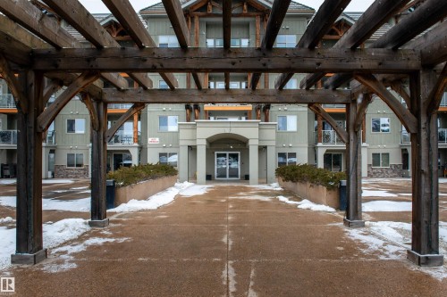 Snow covered property entrance featuring a pergola and stucco siding - 237 278 Suder Greens Drive, Edmonton, AB - Outdoor With Facade